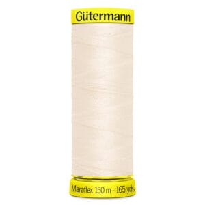 A spool of Gütermann Maraflex thread in a cream color. The spool label indicates the length as 150 meters or 165 yards. The top and bottom of the spool have bright yellow accents with the brand and product information.
