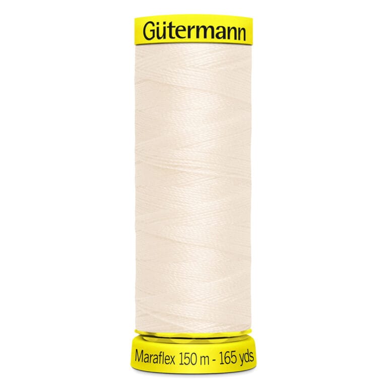 A spool of Gütermann Maraflex thread in a cream color. The spool label indicates the length as 150 meters or 165 yards. The top and bottom of the spool have bright yellow accents with the brand and product information.