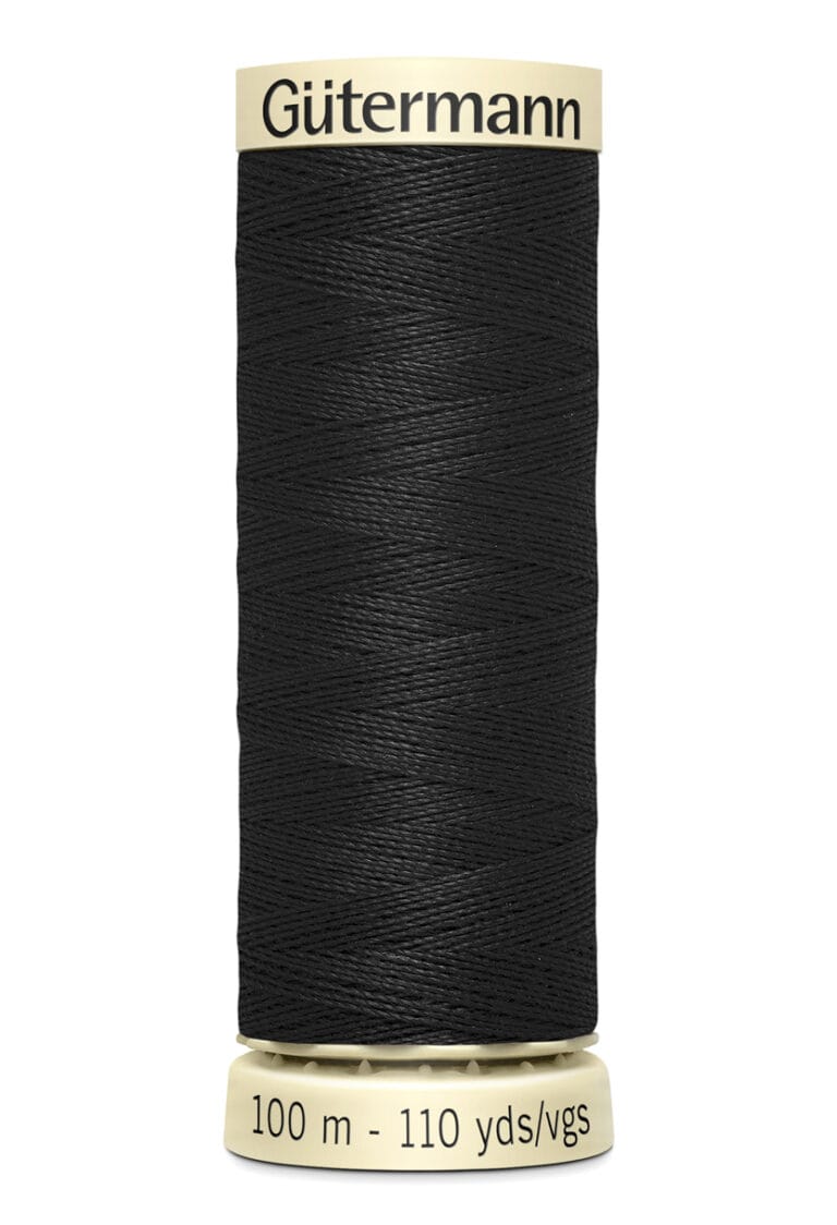 A spool of Gütermann black sewing thread labeled "100 m - 110 yds/vgs." The label and spool ends are cream-colored, providing contrast with the dark thread.