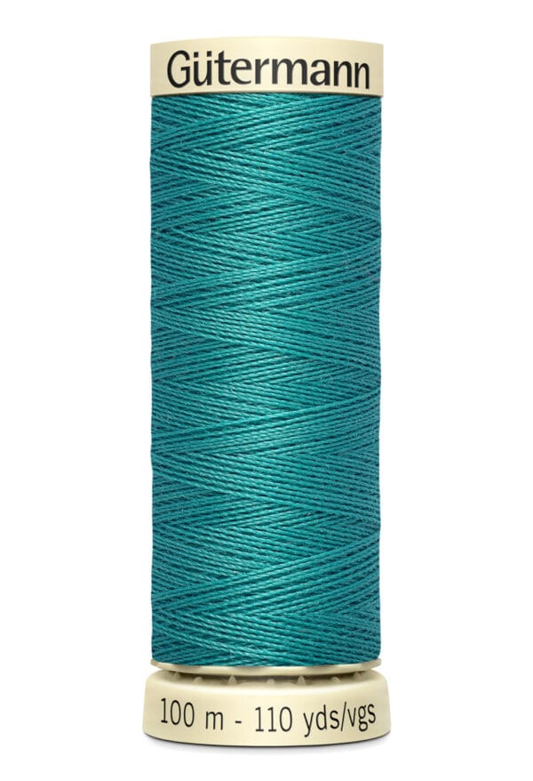 A spool of Gütermann sewing thread in teal, with a label indicating 100 meters or 110 yards. The thread is neatly wound around a beige cylindrical holder with black text.