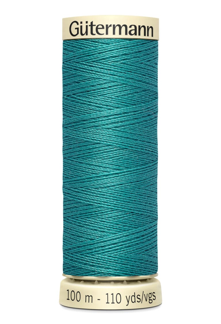 A spool of Gütermann sewing thread in teal, with a label indicating 100 meters or 110 yards. The thread is neatly wound around a beige cylindrical holder with black text.