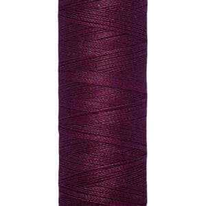 A spool of Gütermann thread in deep purple. The label indicates 100 meters (110 yards) of thread. The spool is beige, with the brand name printed at the top.