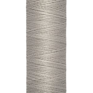 A spool of gray Gütermann sewing thread, labeled with "100 m - 110 yds/vgs" on the base. The spool has a beige top and bottom.