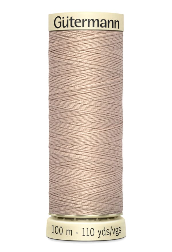 A spool of Gütermann thread in a light brown color, designed for sewing. It has a label at the top and bottom indicating "100 m - 110 yds/vgs.