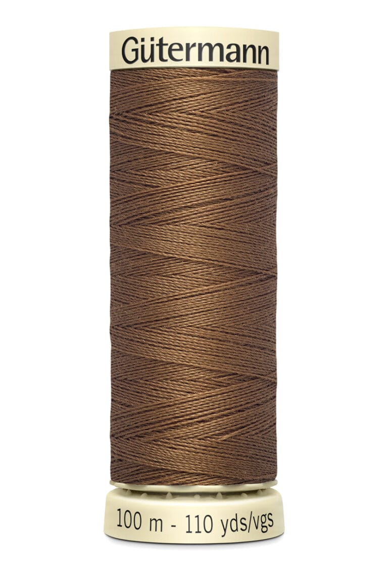 Spool of Gütermann brown sewing thread, labeled with 100 meters and 110 yards, featuring a creamy beige top and bottom lid.