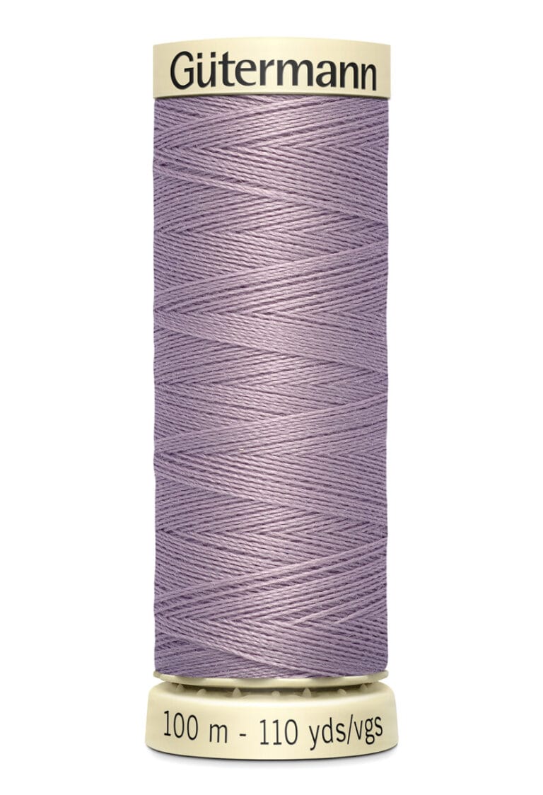 Spool of Gutermann thread, labeled "100 m - 110 yds/vgs," in a light purple color. The spool has cream-colored ends with the brand name printed on the top.