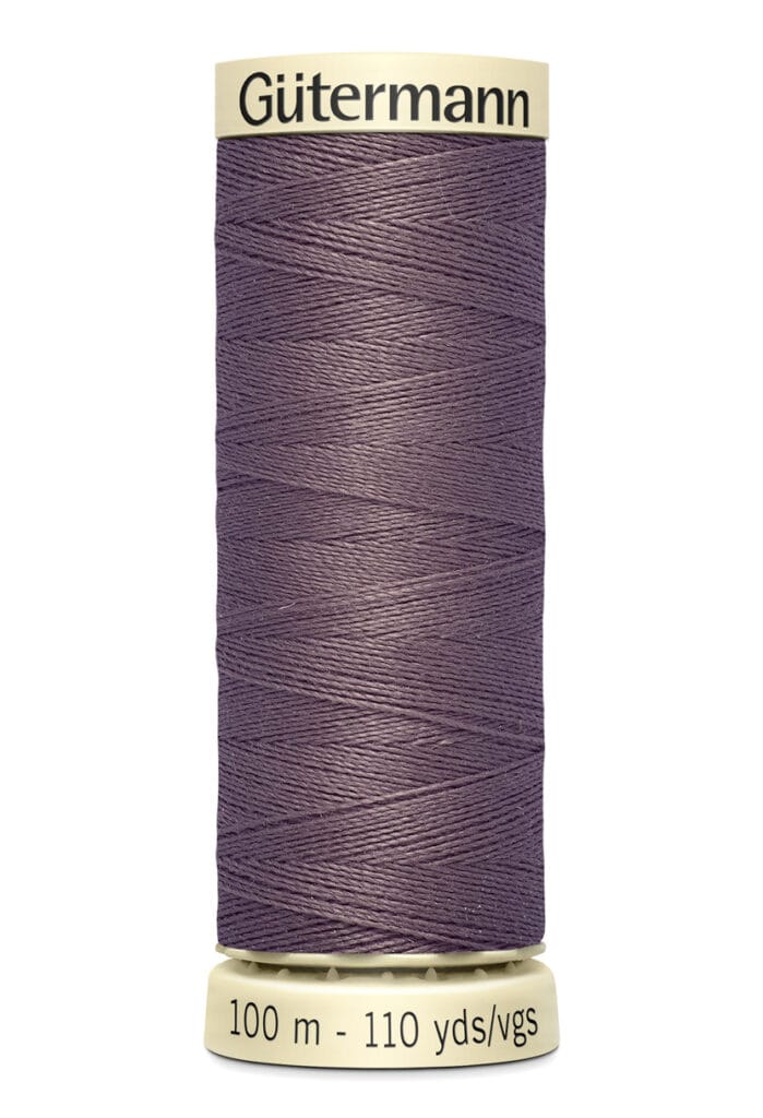 A spool of Gütermann thread in a deep purple color. The spool indicates 100 meters or 110 yards of thread.
