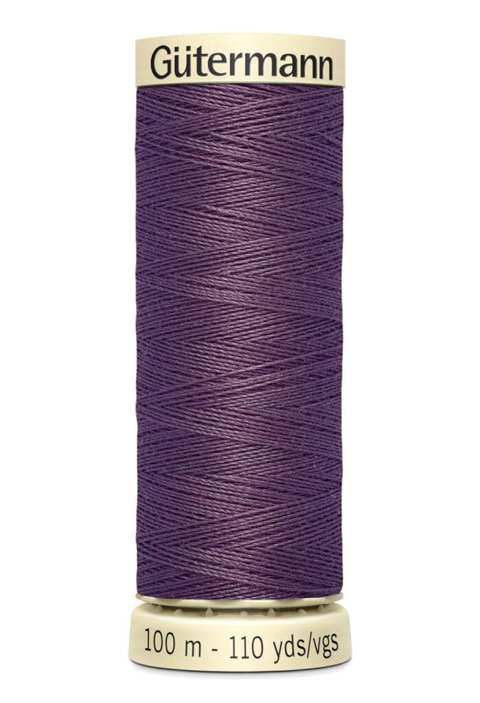 A spool of Gütermann thread in deep purple color, labeled at the bottom with "100m - 110 yds/vgs." The spool is cylindrical with a cream-colored top and bottom.