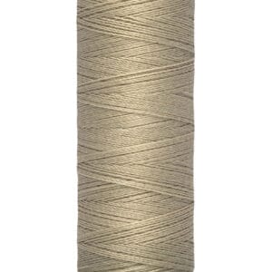 A spool of Gütermann sewing thread in light beige is shown. The spool is labeled with "100 m - 110 yds" and "Gütermann" at the top. The thread is neatly wound around the spool.