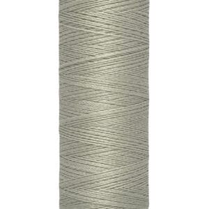 Spool of Gütermann sewing thread in pale grey. It is 100 meters long, equivalent to 110 yards, as indicated on the label at the base.