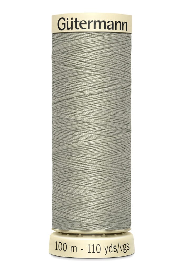Spool of Gütermann sewing thread in pale grey. It is 100 meters long, equivalent to 110 yards, as indicated on the label at the base.