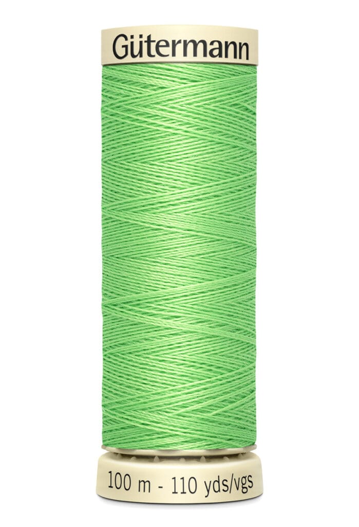 A spool of Gütermann polyester thread in bright green. The spool indicates a length of 100 meters or 110 yards.