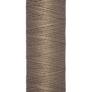 A spool of Gütermann sewing thread in a taupe color, labeled with "100 m - 110 yds/vgs" on the bottom.