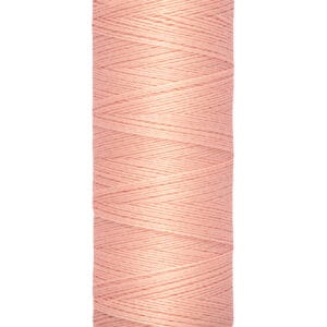 A spool of Gütermann thread in light pink, featuring a crisscross pattern. The base indicates the length as 100 meters or 110 yards.