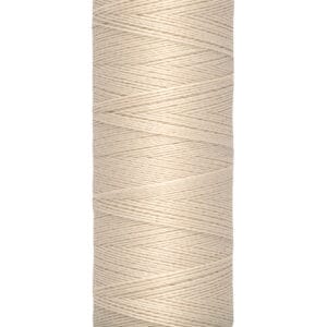 Spool of Gütermann sewing thread in beige, wrapped tightly around a cylindrical cream-colored spool. Labeled with "Gütermann" and "100 m - 110 yds/vgs.