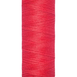 A spool of Gütermann sewing thread in bright red, with a label displaying "100 m - 110 yds/vgs." The spool has beige ends with the brand name printed on the top.