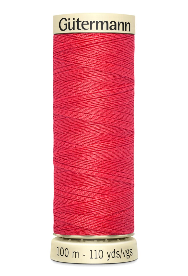 A spool of Gütermann sewing thread in bright red, with a label displaying "100 m - 110 yds/vgs." The spool has beige ends with the brand name printed on the top.