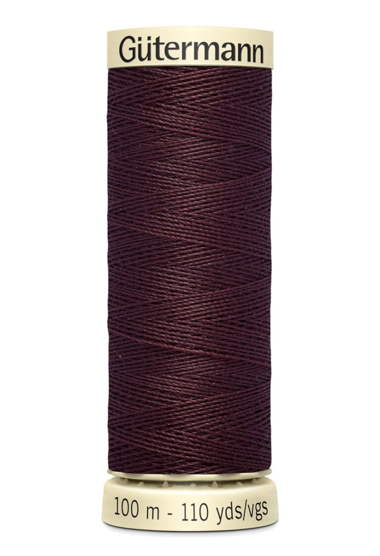 A spool of Gütermann thread in deep burgundy color. The label on the spool reads "100 m - 110 yds/vgs." The thread is tightly wound around the cylindrical spool, with a beige top and base.