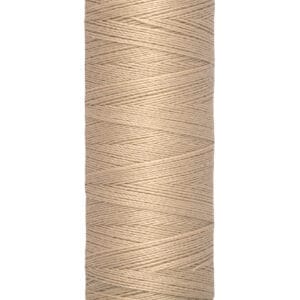 A spool of Gütermann thread in light beige, wound neatly, with labels showing "100 m - 110 yds/vgs.