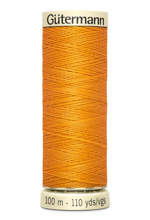 A spool of Gütermann thread in a bright orange color, labeled with measurements of 100 meters and 110 yards. The spool has a cream-colored top and bottom with black text.