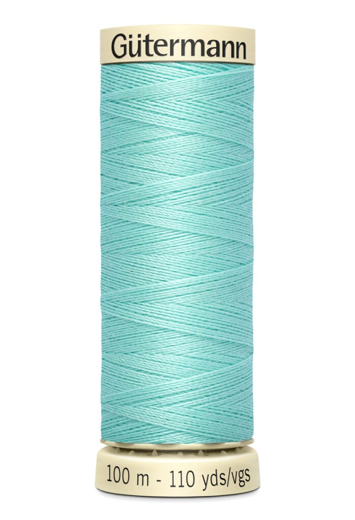 A spool of turquoise Gütermann sewing thread, with labels indicating 100 meters and 110 yards. The spool is cream-colored on top and bottom.