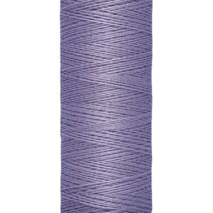 A spool of Gütermann sewing thread in light purple, labeled with "100 m - 110 yds/vgs." The spool is beige with the brand name written on top. The thread is wound neatly around the spool.