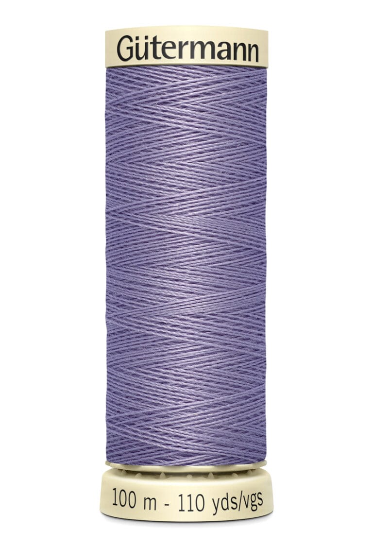 A spool of Gütermann sewing thread in light purple, labeled with "100 m - 110 yds/vgs." The spool is beige with the brand name written on top. The thread is wound neatly around the spool.