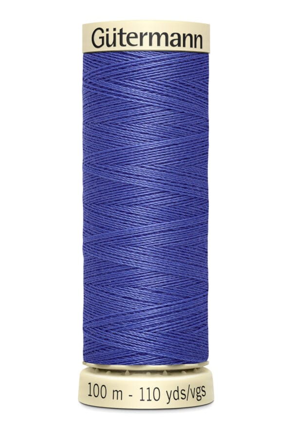 A spool of Gütermann thread in royal blue, showing its tightly wound texture. The spool's label reads "100 m - 110 yds/vgs" in black text on a light beige base and top.