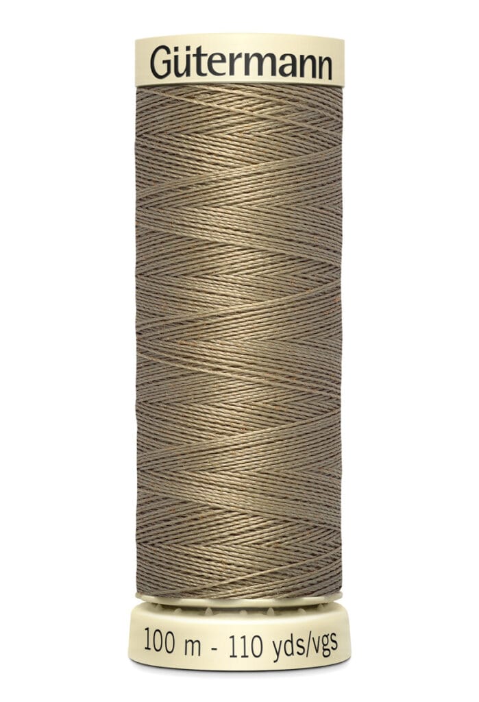 A spool of Gütermann sewing thread, beige in color, with labels indicating 100 meters or 110 yards of length. The spool is vertically oriented and has a light yellow base and top.