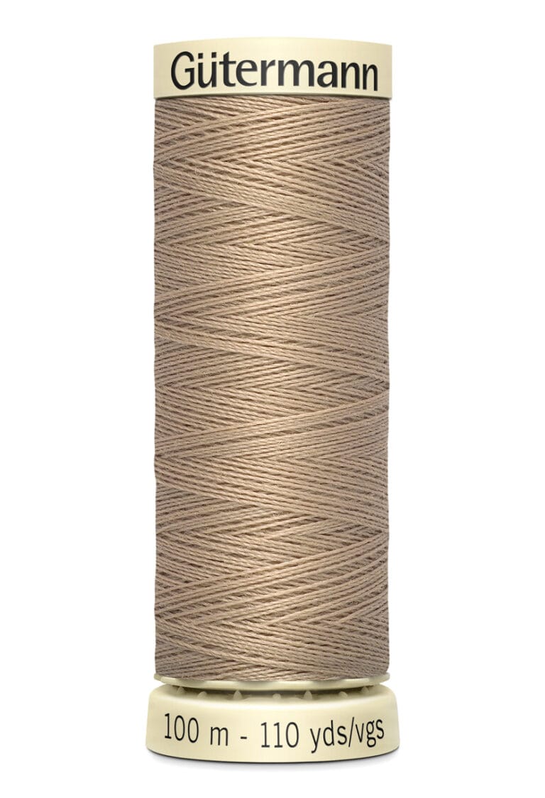 A spool of Gütermann thread in a beige color. The thread is neatly wound, and the spool label shows "100 m - 110 yds/vgs.