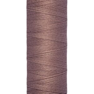 Spool of Gütermann sewing thread in a dusty rose color, with 100 meters (110 yards) indicated on the bottom label.