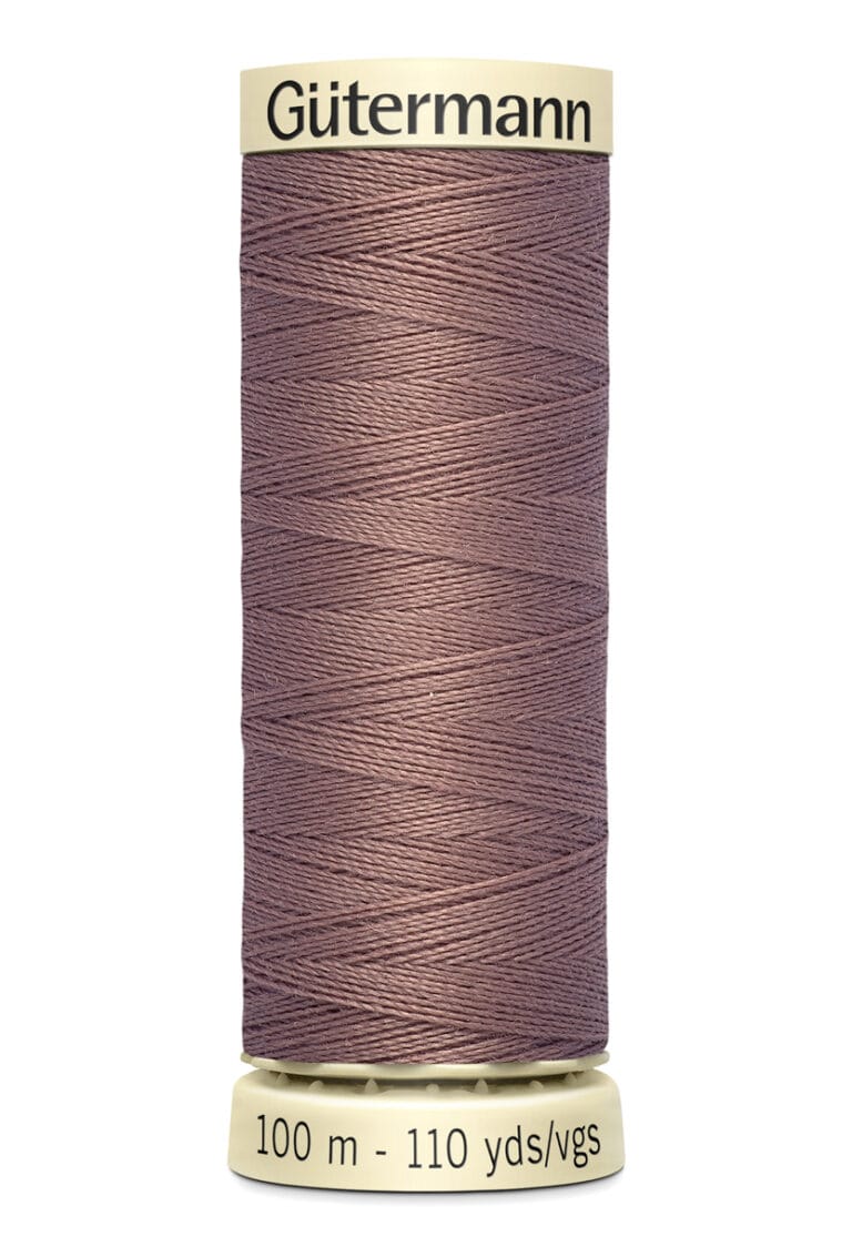 Spool of Gütermann sewing thread in a dusty rose color, with 100 meters (110 yards) indicated on the bottom label.