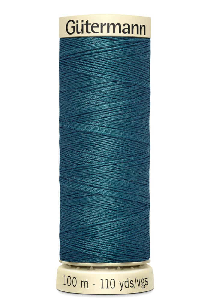 A spool of Gütermann sewing thread, 100 meters (110 yards) long, in a deep teal color. The spool is cream-colored, and the brand name is printed on the top edge.
