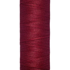 A spool of Gütermann thread, filled with deep red thread. The label indicates a length of 100 meters or 110 yards. The spool is cream-colored with black text.