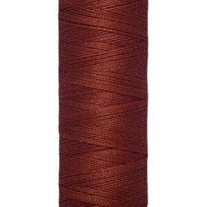 Spool of Gütermann thread in deep burgundy color, labeled with "100 m - 110 yds." The spool is cylindrical with a beige top and bottom.