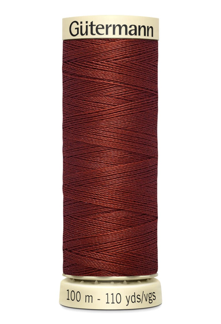 Spool of Gütermann thread in deep burgundy color, labeled with "100 m - 110 yds." The spool is cylindrical with a beige top and bottom.