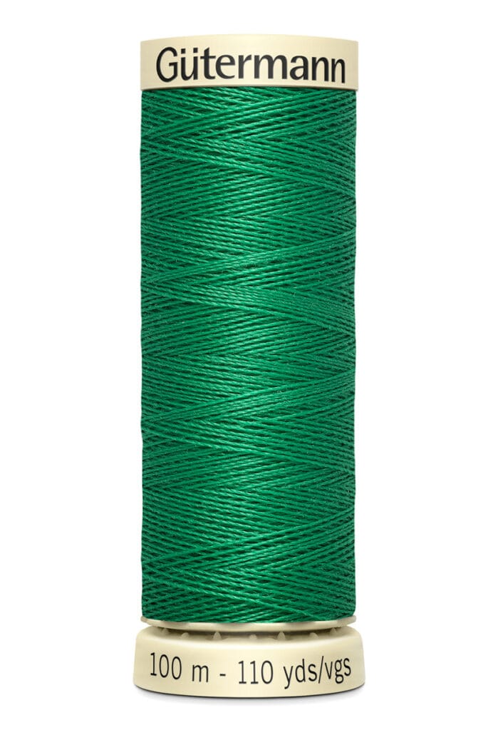 A spool of Gütermann thread, featuring vibrant green thread. The spool label indicates a length of 100 meters or 110 yards.