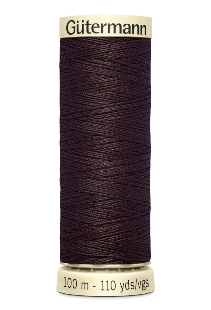 A spool of Gütermann thread, dark brown in color, with a label indicating 100 meters or 110 yards. The label is cream-colored with black text.
