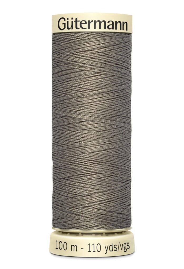 A spool of Gütermann sewing thread, grey in color, with text on the top and base. The base indicates the length as 100 meters or 110 yards. The thread is neatly wound around the spool.