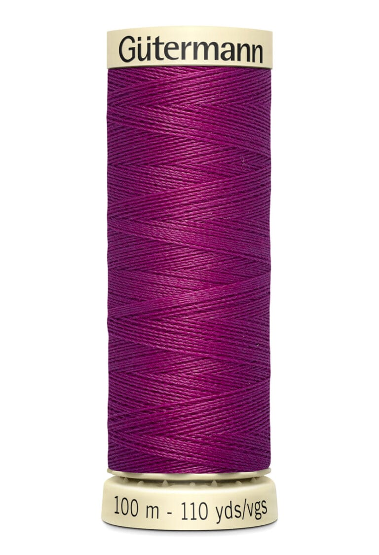 A spool of Gütermann thread with bold magenta color, labeled 100 meters (110 yards). The spool is cream-colored with black text on the top and base.