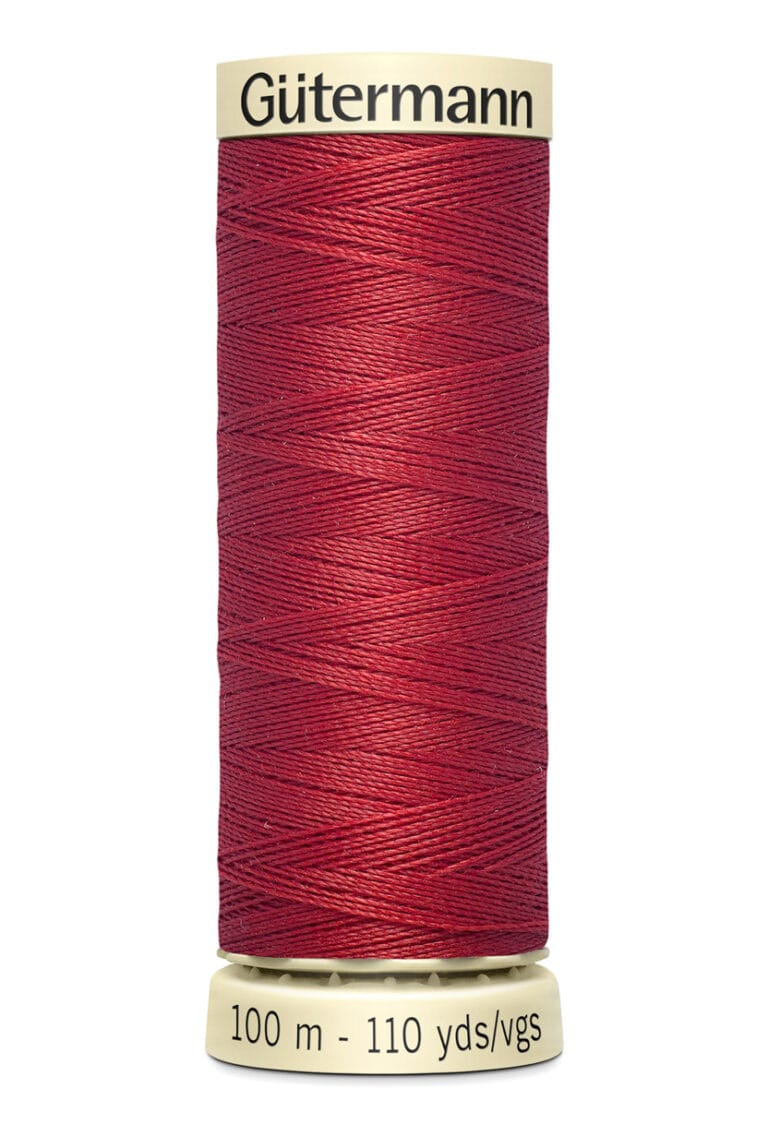 A spool of Gütermann red sewing thread, showing fine texture. The spool is labeled with "100 m - 110 yds/vgs.