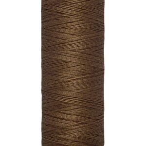 A spool of Gütermann brown thread with a beige label, marked "100 m - 110 yds." The thread is tightly wound around the spool, showcasing its smooth texture and rich color.