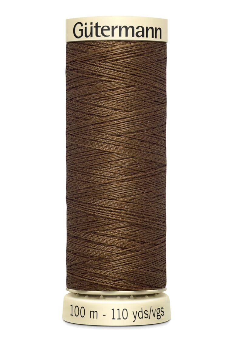 A spool of Gütermann brown thread with a beige label, marked "100 m - 110 yds." The thread is tightly wound around the spool, showcasing its smooth texture and rich color.