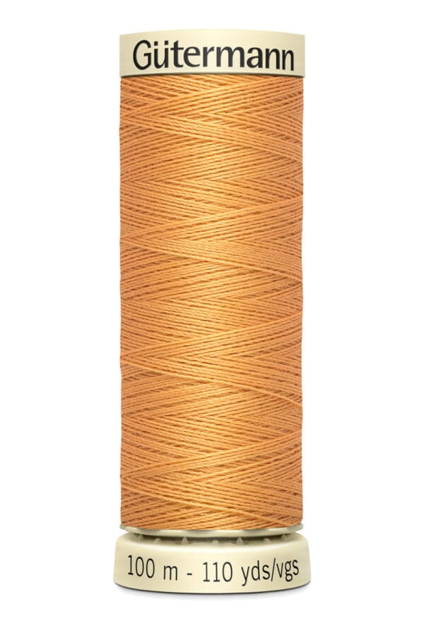 A spool of Gütermann thread in a light brown color, with labels indicating 100 meters and 110 yards. The thread is neatly wound around a beige spool.