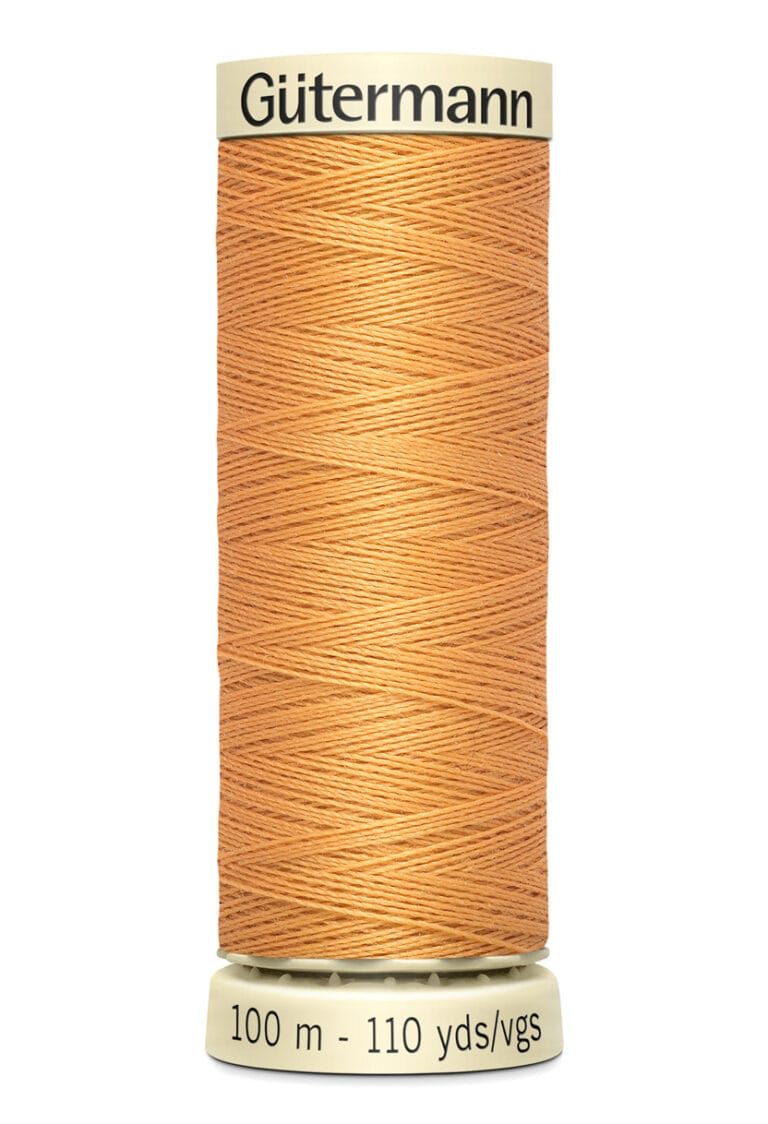 A spool of Gütermann thread in a light brown color, with labels indicating 100 meters and 110 yards. The thread is neatly wound around a beige spool.