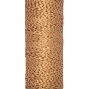 A spool of Gütermann sewing thread in light brown color. The spool has labels indicating 100 meters or 110 yards of thread.