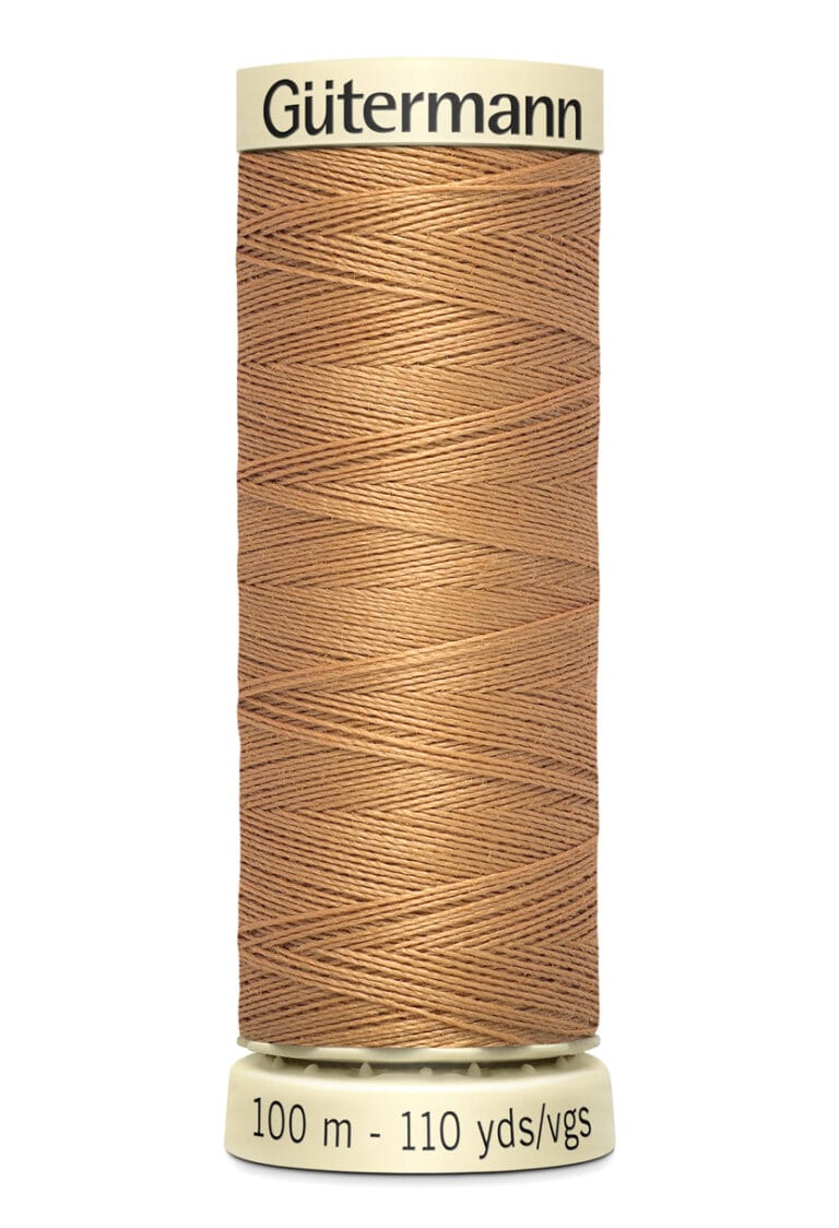 A spool of Gütermann sewing thread in light brown color. The spool has labels indicating 100 meters or 110 yards of thread.