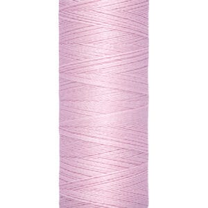 A spool of pale pink Gütermann sewing thread on a beige holder, labeled with "100 m - 110 yds/vgs".