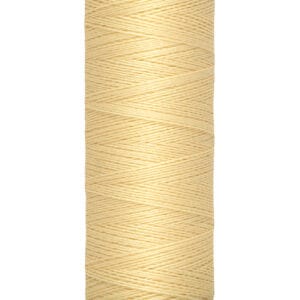 A spool of Gütermann thread in light yellow color, labeled with "100 m - 110 yds/vgs" indicating its length. The spool is upright with the brand name visible at the top.