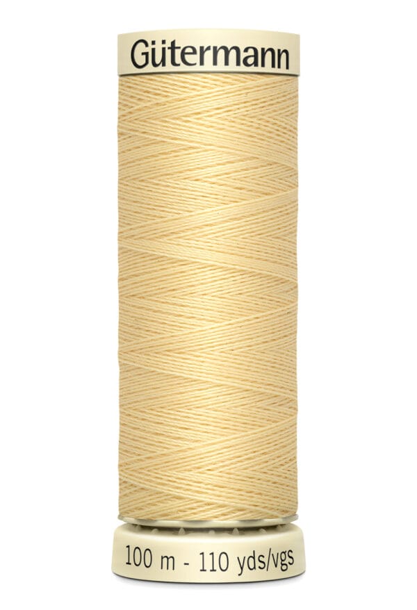 A spool of Gütermann thread in light yellow color, labeled with "100 m - 110 yds/vgs" indicating its length. The spool is upright with the brand name visible at the top.